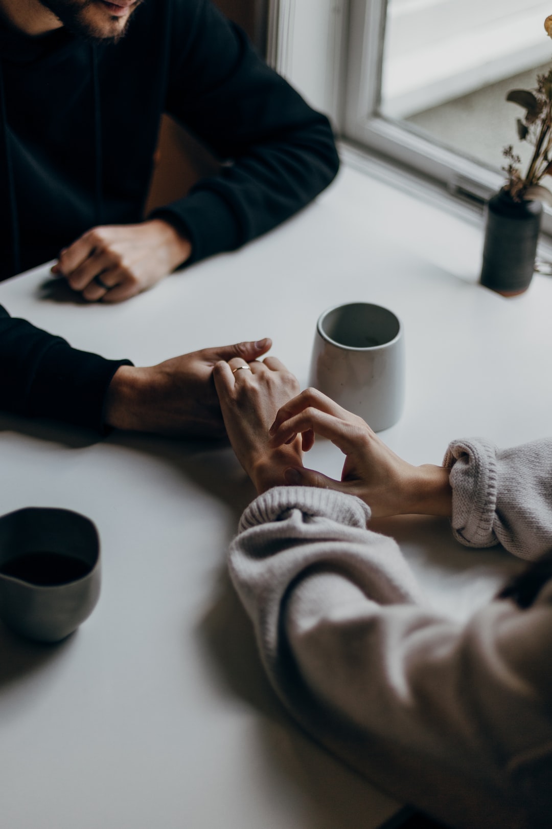 couple holding hands having a conversation in a cafe. 